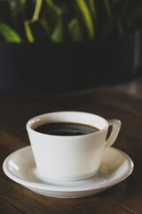 Hot coffee in white mug with dark backdrop. Freshly brewed coffee against black background. Cup of coffee on dark background.