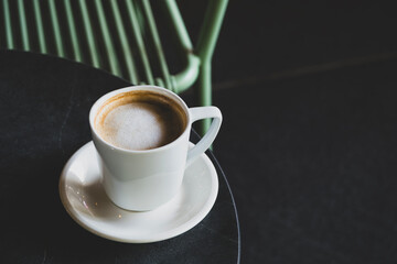 Hot latte coffee in white cup. Cappuccino style latte on table. Cup of latte with frothy milk. Freshly brewed latte with milk foam.