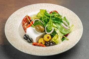Greek salad with feta cheese, olives, and fresh vegetables on a plate