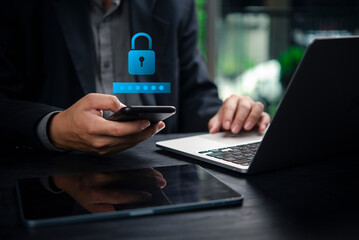 Businessman using smartphone and laptop with digital lock icon, representing cybersecurity, data protection, password security, online privacy, and secure technology in business.