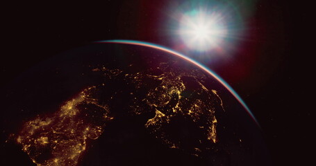 A vibrant sunrise illuminates the Earth as seen from space, highlighting the continents and city lights against the dark backdrop of space. The contrast is breathtaking and serene.
