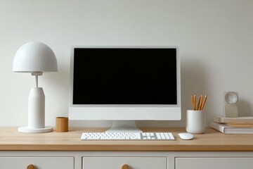 Fototapeta premium A minimalist workspace featuring a computer, lamp, and accessories on a light wooden desk