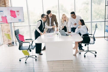 Team meeting in a modern office with colleagues collaborating on a project around a table showcasing teamwork and innovation