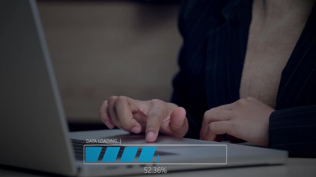 Close-up of female hands typing on a laptop with a digital &ldquo;Data Loading&rdquo; progress bar displayed on screen