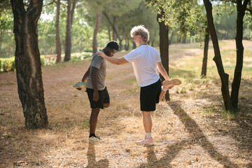 Two young men stretching together before exercising outdoors