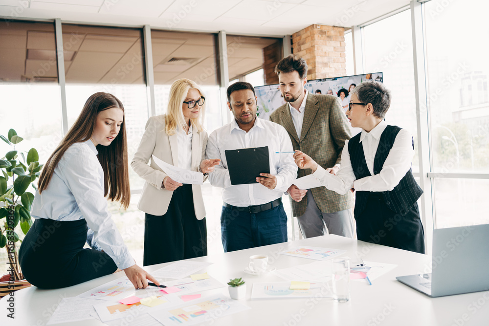 Poster group of professionals engaging in teamwork and discussion with documents in an office setting