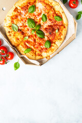 Pizza Margarita in a cardboard box on white background.