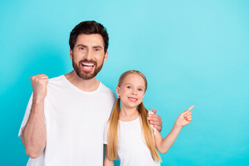 Dad and Daughter Bonding Together with Joyful Expressions on Vibrant Turquoise Background in Casual Clothing Celebrating a Happy Moment