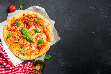 Pizza margarita on black background with ingredients for cooking.