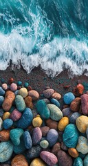 Vibrant, colorful pebbles meet the turquoise ocean waves