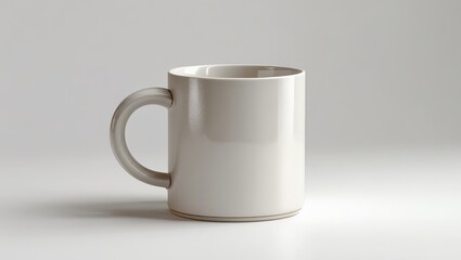 Obraz premium A light gray mug with a simple, rounded handle stands on a plain white background.