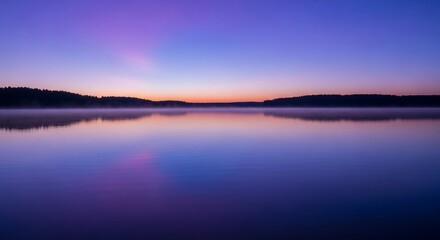 Fototapeta premium Peaceful sunrise over a calm lake, reflecting vibrant colors in the still water.