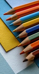 Colorful pencils arranged on layered papers