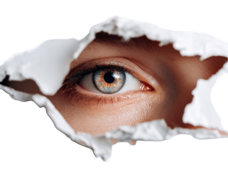 A close-up eye peeking through torn paper
