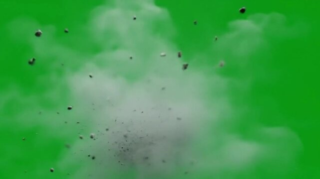 A grey dust cloud explodes against a vibrant green screen, small debris particles dispersing outwards.