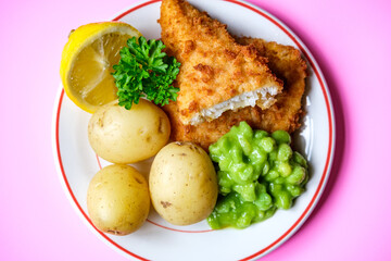 Breaded Cod Fish Fillet With Boiled New Potatoes And Mushy Peas