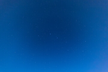 Fototapeta premium A serene night sky filled with countless twinkling stars scattered across deep blue darkness, capturing the quiet beauty of the cosmos.