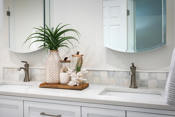 Fototapeta premium Detail of double bathroom sink with white and gray marble top and styled with sea coral and greenery.