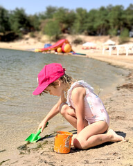 A girl is building a sand castle on the beach.