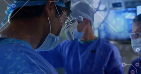 Operating surgeon wearing loupe performing surgery in operating room with monitors copy space