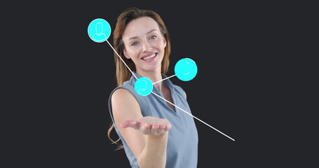 Presenting mid adult female extending palm toward camera in studio, with turquoise icons