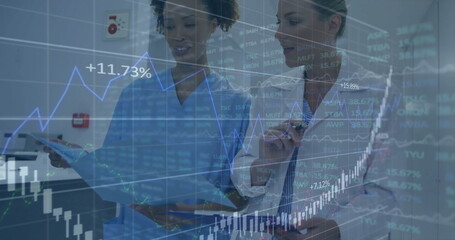 Scrub nurse and doctor in lab coat analyzing graphs in hospital corridor, with blue folder tablet