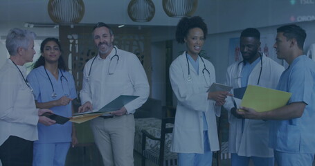 Discussing medical professionals reviewing patient charts in hospital lounge, with stethoscopes