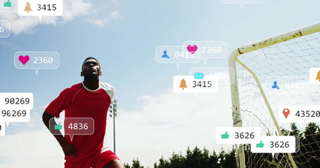 Standing soccer player in red uniform scanning sky beside goal, with social media icons copy space
