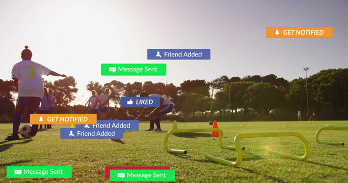 Six soccer players dribbling ball through cones hurdles on turf at sunset, with digital alerts