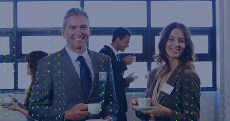 Smiling businessman and colleague holding coffee cups in conference break area, with coffee carafe
