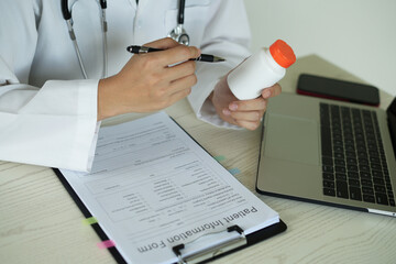 Young professional female doctor taking notes in journal, physician therapist practitioner filling...