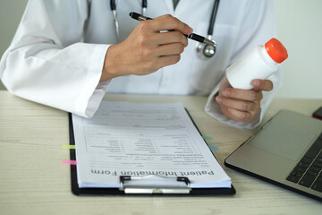 Young professional female doctor taking notes in journal, physician therapist practitioner filling...