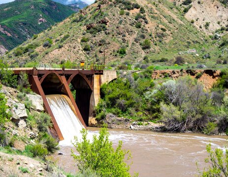 Mountain river flows through a dam - Powered by Adobe