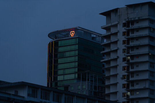KUALA LUMPUR, MALAYSIA - AUG 16, 2025: TNB (Tenaga Nasional Berhad) building with illuminated logo at the top, captured during blue hour in an urban cityscape setting in Malaysia.