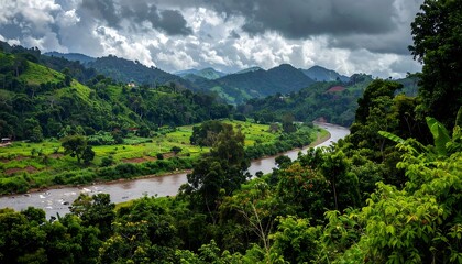 Obraz premium Lush green valley landscape with a meandering river under a dramatic sky.