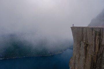 Breathtaking view from Preikestolen Cliff overlooking the misty waters of Norway