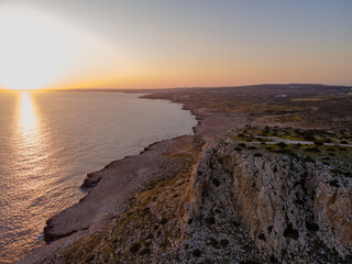 Aerial View of Cyprus Coastline with Cliffs, Beach, and Sunset
