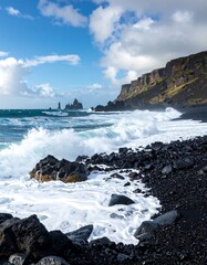 Dramatic waves crash against dark volcanic rocks on a serene black sand beach, showcasing dramatic coastal scenery.