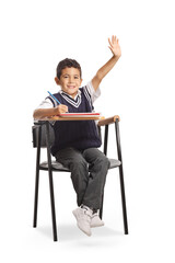 Boy sitting in a school chair and raising arm