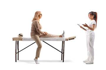 Obraz premium Physical therapist in a white uniform holding a clipboard and talking to a female patient