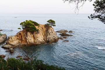 Beautiful rocky coast of Fenals in Lloret de Mar, featuring turquoise waters, rugged cliffs, and...