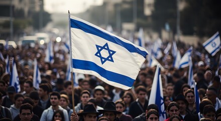 A sea of people march under the Israeli flag, a symbol of national pride and unity. The crowd flows forward, carrying the flag high