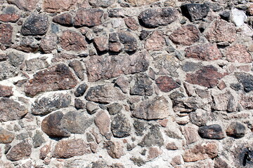 Abstract texture from a wall lined with large stones.