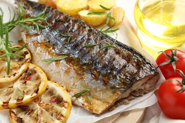 Tasty roasted mackerel served with spices and vegetables on table, closeup. Homemade seafood dish