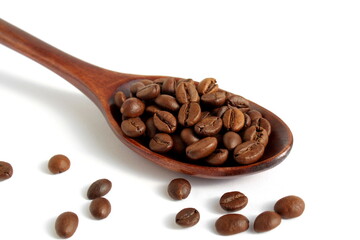 On a white background lies a wooden spoon with coffee beans	