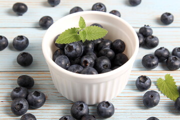 There is a bowl of ripe blueberries on the table.