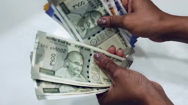 Money counting in bank on isolated background, an india currency rupee notes, 500, 100, and 200 notes.