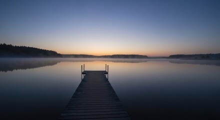 Obraz premium Peaceful sunrise over a lake with a wooden dock. Tranquil morning light reflecting on the still water