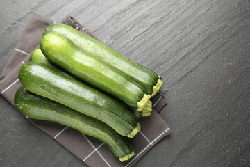 Fresh ripe zucchinis on black table, top view. Space for text