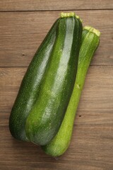 Fresh ripe zucchinis on wooden table, top view